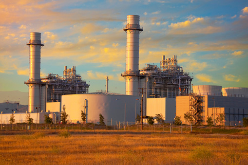 A sprawling industrial plant with two towering chimneys