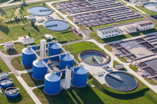 Aerial view of a water treatment plant with large tanks and pipelines